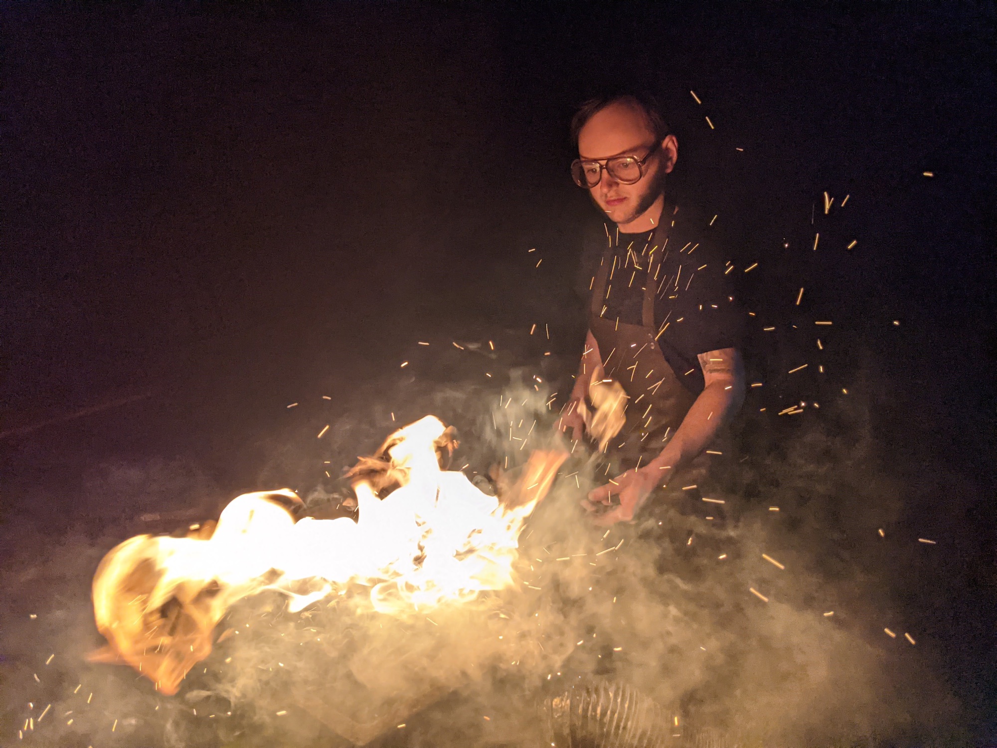 A blacksmith working amid sparks and flame at night in Germany
